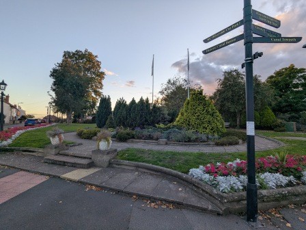 fingerpost in front of formal gardens