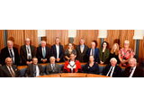 group of people sat behind curved desk, man in mayoral robes in centre