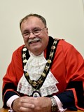 smiling man in mayoral robes