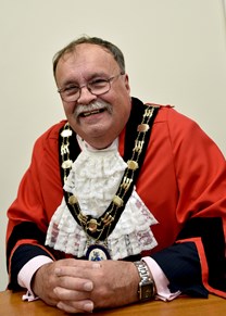 smiling man in mayoral robes